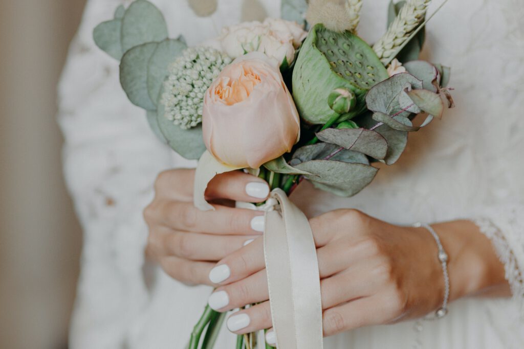 Braut mit schönem Blumenstrauß bereitet sich auf die Hochzeit vor